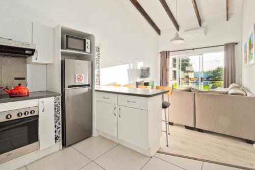 a kitchen with white appliances and a large window at Stunning Knysna central Apartment in Knysna