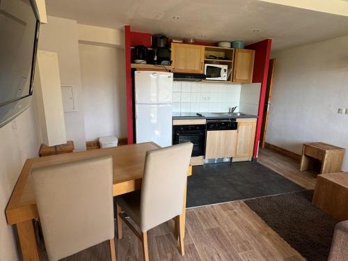 une petite cuisine avec une table et un réfrigérateur dans l'établissement Studio cabine avec balcon, piscine, spa, animaux admis, accès direct pistes - Belle Plagne - FR-1-181-2825, à La Plagne Tarentaise