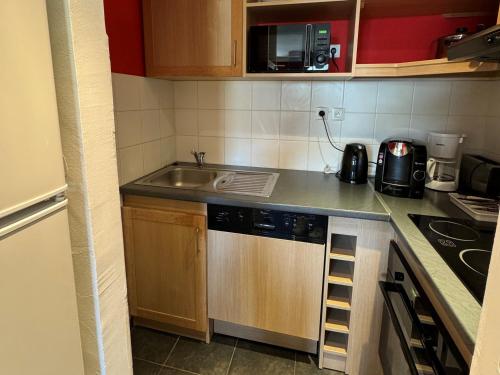 Il comprend une petite cuisine équipée d'un évier et d'un lave-vaisselle. dans l'établissement Appartement cosy avec balcon, piscine & détente, ski aux pieds - Belle Plagne - FR-1-181-2820, à La Plagne Tarentaise