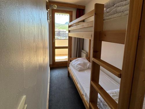 Cette chambre comprend 2 lits superposés et une fenêtre. dans l'établissement Appartement cosy avec balcon, piscine & détente, ski aux pieds - Belle Plagne - FR-1-181-2820, à La Plagne Tarentaise