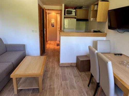 un salon avec un canapé et une table et une cuisine dans l'établissement Duplex cosy à Belle Plagne - Ski aux pieds, balcon, piscine, bien-être, animaux admis - FR-1-181-2821, à La Plagne Tarentaise