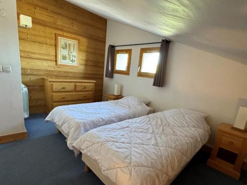 - 2 lits dans une chambre dotée de murs en bois dans l'établissement Duplex cosy à Belle Plagne - Ski aux pieds, balcon, piscine, bien-être, animaux admis - FR-1-181-2821, à La Plagne Tarentaise