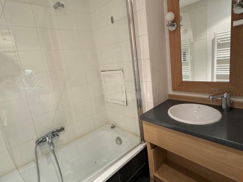 une salle de bain avec un lavabo, une douche et une baignoire dans l'établissement Studio ski aux pieds avec piscine chauffée, WiFi et animaux admis - FR-1-181-2822, à La Plagne Tarentaise