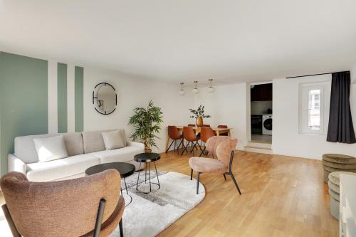 un salon avec un canapé blanc et des chaises dans l'établissement Pick A Flat's Apartement in Saint-Martin - Rue du faubourg Saint-Martin, à Paris