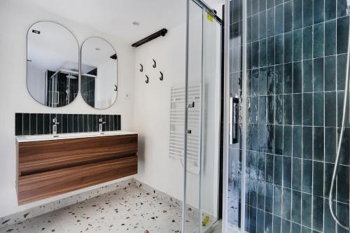 une salle de bain avec deux lavabos et une douche en verre dans l'établissement Pick A Flat's Apartement in Saint-Martin - Rue du faubourg Saint-Martin, à Paris