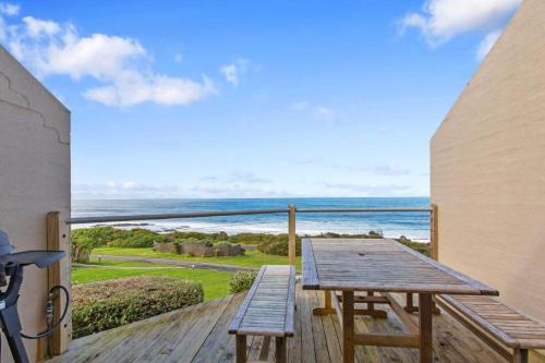 a wooden deck with a table and a view of the ocean at 9 Whitecrest Great Ocean Road Resort - Ocean View in Apollo Bay