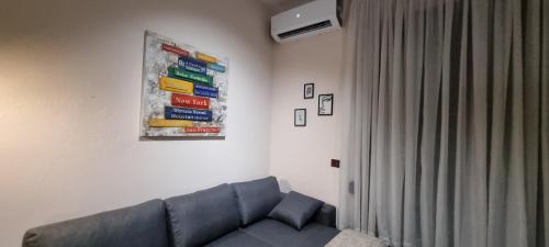 a living room with a couch and a poster on the wall at Matt House beachside in Durrës