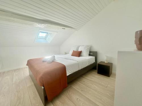 une chambre avec un lit dans une pièce blanche dans l'établissement Les Bancs, central et calme, à Limoges