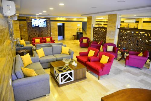 a living room with colorful chairs and couches at Petra Corner Hotel in Petra