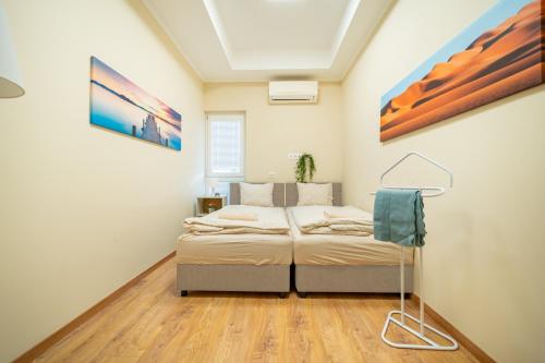 a bedroom with a bed and a painting on the wall at Palmy Home Dunakeszi in Dunakeszi