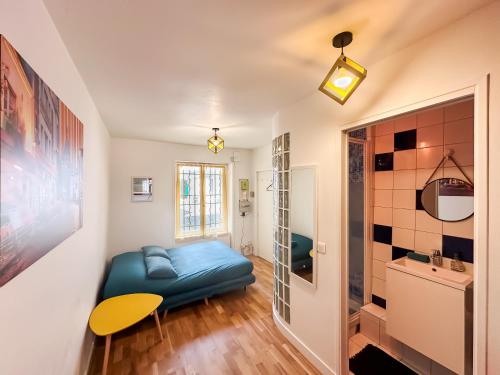 un salon avec un canapé bleu et une table dans l'établissement Heart of Montmartre Cute & Cozy, à Paris