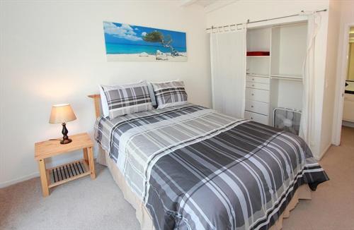 a bedroom with a bed and a table with a lamp at 124 Thirty Fourth Street B in Newport Beach