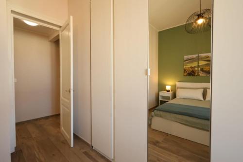 クーネオにあるBarolo Apartmentのベッドルーム(ベッド1台、鏡付)