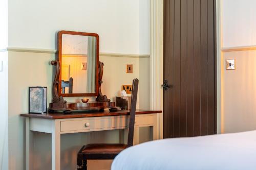 a bedroom with a dressing table with a mirror at Woolpack Inn in Canterbury