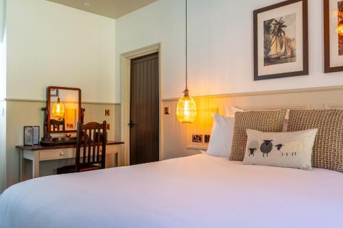 a bedroom with a white bed and a mirror at Woolpack Inn in Canterbury