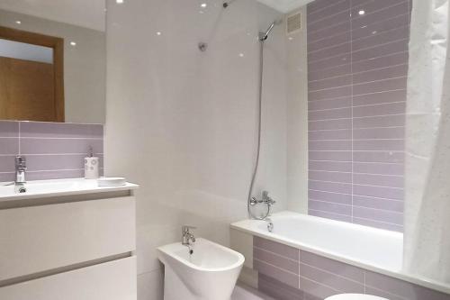 un bagno con vasca, WC e lavandino di Luma, apartamento con terraza a Cambados