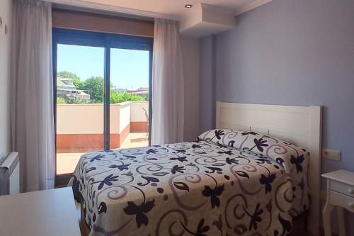una camera da letto con un letto e una grande finestra di Luma, apartamento con terraza a Cambados