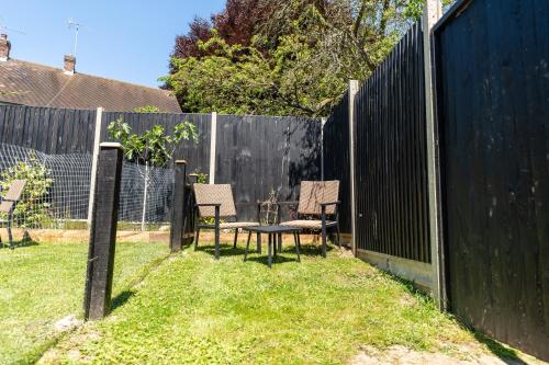a backyard with two chairs and a table and a fence at Woolpack Inn in Canterbury