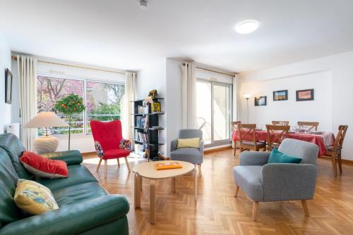 un salon avec un canapé vert et des chaises dans l'établissement L'Azalée - 106m2 quartier Monplaisir Lyon 8, à Lyon
