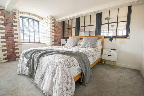 a bedroom with a bed and a brick wall at The Robinson Building in Bristol
