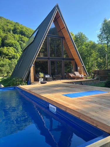 a house with a triangular roof and a pool at Hygge Cabana in Malaia