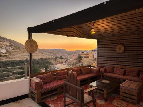 a balcony with couches and a view of the mountains at Petra Corner Hotel in Petra