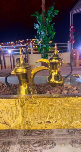 two gold urns sitting on top of a table at Petra Corner Hotel in Petra