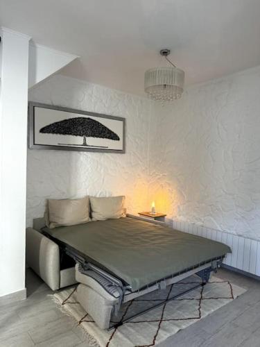 - une chambre avec un lit dans un mur blanc dans l'établissement Maison proche stade de France, à Aubervilliers