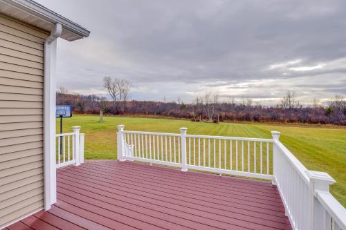 a wooden porch with a white fence and a field at Family Home Near Beach about 6 Mi to Dtwn Canandaigua in Canandaigua
