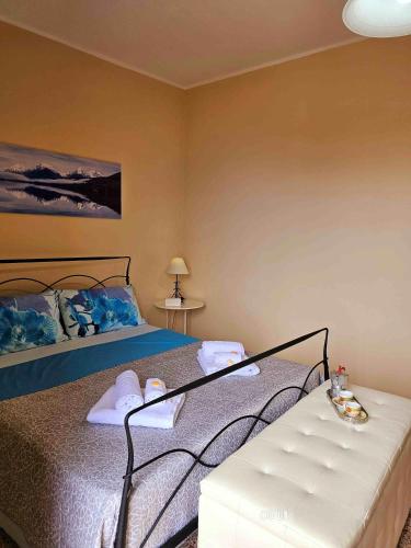 a bedroom with a bed and a bench in it at Petralia Guest House in Castelmola