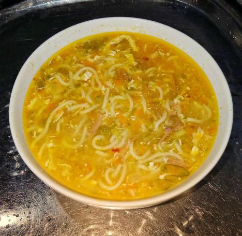 a bowl of soup with noodles on a table at Venora Hiriketiya in Dickwella