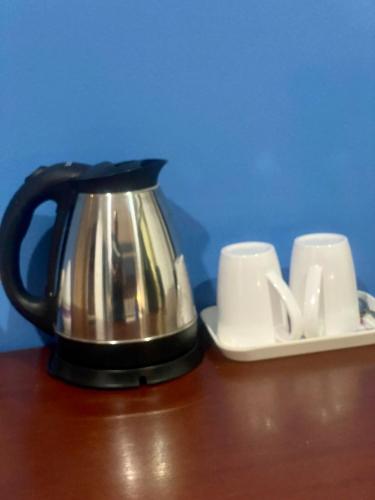 a tea kettle and two cups on a table at Kata Guesthouse Tuscany in Kata Beach