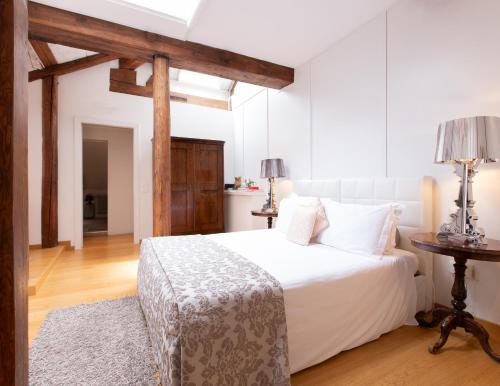 a bedroom with a white bed and a table at Palazzetto Pisani Grand Canal in Venice