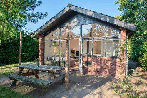 a greenhouse with a picnic table in front of it at Loohuisje 43 in Aalten