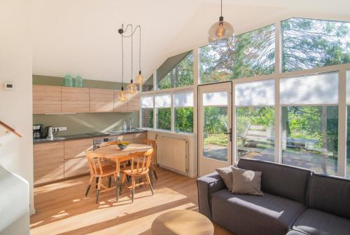 a kitchen and living room with a table and a couch at Loohuisje 43 in Aalten