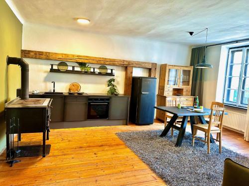 a kitchen and dining room with a table and a refrigerator at Stadtjuwel am Neusiedlersee in Rust