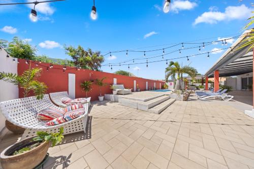 a patio with chairs and a fence with lights at Ierlandstraat 23 in Oranjestad
