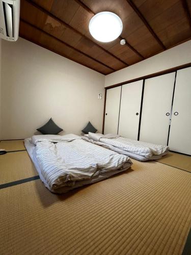a room with two beds in a room with a ceiling at 金の森民泊 in Osaka