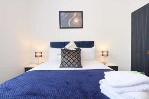 a bedroom with a blue bed with towels on it at Alliance 209 in Bristol