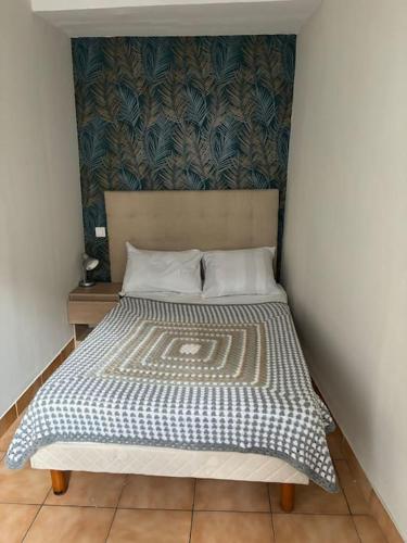 - un lit dans une chambre avec un mur dans l'établissement Cœur historique de Grasse, à Grasse