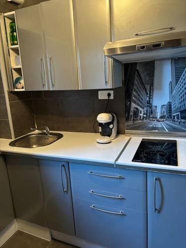 une petite cuisine avec un évier et une cuisinière dans l'établissement Cœur historique de Grasse, à Grasse