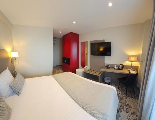 a hotel room with a large bed and a desk at Europe Haguenau – Hotel & Spa in Haguenau
