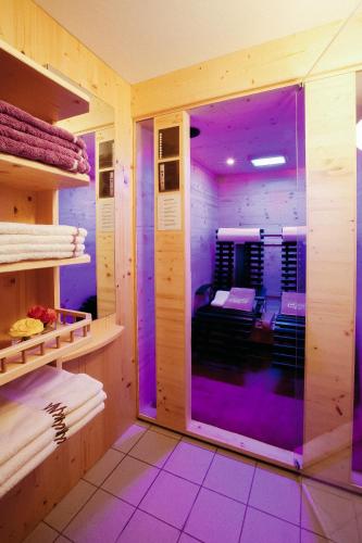 a room with purple lighting in a room with shelves at Hotel Kristall in Lech am Arlberg