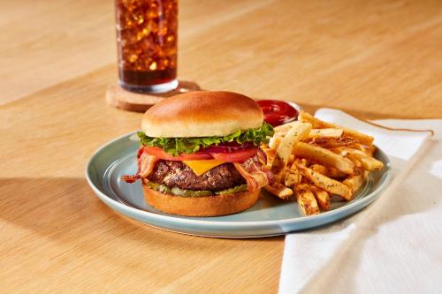 a plate with a hamburger and french fries on a table at Holiday Inn Baton Rouge College Drive I-10 by IHG in Baton Rouge