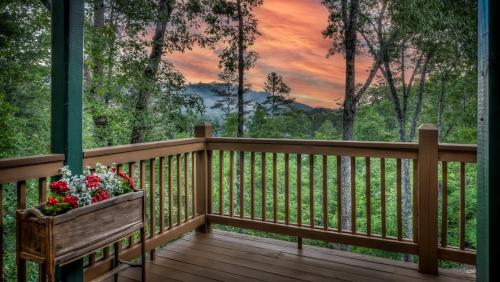a wooden deck with a bench with flowers on it at Memory Maker in Blue Ridge