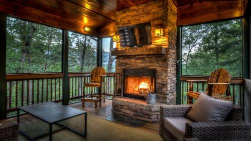 a living room with a fireplace on a porch at Memory Maker in Blue Ridge