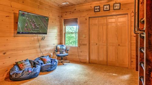 a living room with a tv in a log cabin at Memory Maker in Blue Ridge