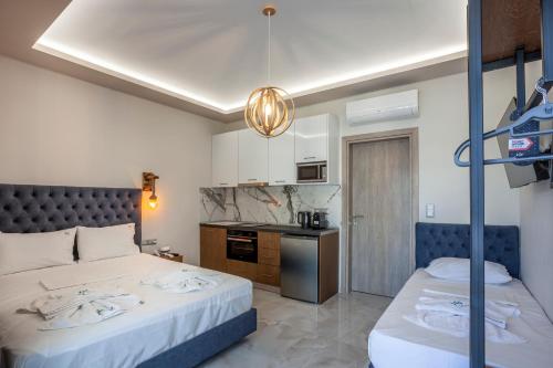a hotel room with two beds and a kitchen at Olia seaside residence 120m from the beach in Pefkochori