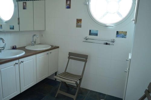 La salle de bains est pourvue de 2 lavabos et d'une chaise en bois. dans l'établissement Villa 4 pièces- Argelès sur mer AR000-021, à Argelès-sur-Mer