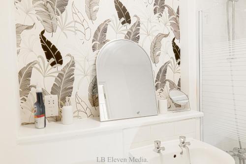 a bathroom with a mirror and a sink at Cozy Haven Flat in Milton Keynes